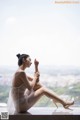 A woman sitting on a window sill with her legs crossed.