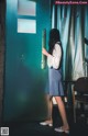 A woman standing in front of a blue door with a sign on it.