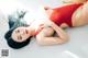 A woman in a red bathing suit laying on the floor.