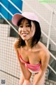 A woman in a pink bathing suit and a pink hat.