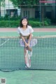 A young woman holding a tennis racket on a tennis court.