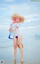 A woman in a straw hat is standing in the water.