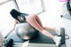 A woman is sitting on an exercise ball in a gym.