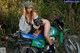 A woman sitting on top of a green motorcycle.