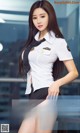 A woman in a white shirt and black skirt posing for a picture.