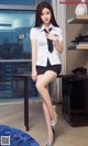 A woman in a white shirt and black skirt posing for a picture.