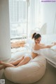 A woman laying on a bean bag chair in a bedroom.