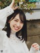 A woman in a white blouse smiles at the camera.