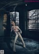 A woman sitting on a chair in an abandoned building.