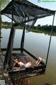 A woman laying on a dock next to a body of water.