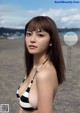 A woman in a bikini standing on a beach.