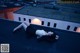 A woman laying on top of a roof next to a building.