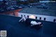 A woman laying on top of a roof next to a building.