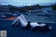 A woman laying on top of a roof with her legs crossed.