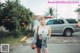 A woman standing in the middle of a parking lot.