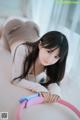 A woman laying on a bed with a pink and blue toy.