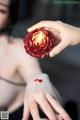 A woman holding a candle in her hand with blood on it.