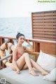 A woman in a pink bathing suit sitting on a couch.