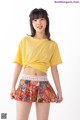 a woman in a yellow shirt and a colorful skirt