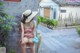 A woman in a straw hat is sitting on a bench.