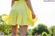 A woman in a yellow skirt is walking in a field.