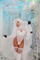 A woman in a white wedding dress and gloves posing for a picture.