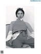 A black and white photo of a woman sitting on a chair.