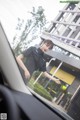 A woman standing next to a car in front of a building.