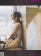 A woman sitting on a bench looking out a window.