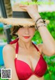 A woman in a red bikini and a straw hat.