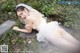 A woman in a wedding dress laying on the ground.