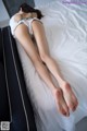 A woman laying on top of a bed with her feet up.