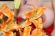 A woman in a red dress holding a bunch of orange flowers.