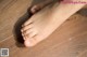 A woman's bare feet on a wooden floor.