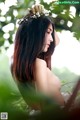 A woman with a flower crown on her head in the woods.