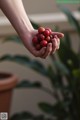 A person holding a handful of coffee beans in their hand.