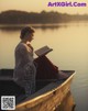 A woman sitting in a boat reading a book.