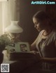 A woman sitting at a table reading a book.