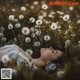 A woman laying in a field of dandelions.