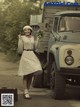 A woman standing in front of a truck holding a bouquet of flowers.