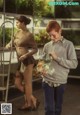 A man holding a fish in a glass jar next to a woman.