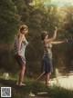 Two women standing next to each other near a body of water.