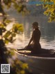 A woman sitting in a canoe on a lake.