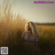 A woman sitting in a field of tall grass.