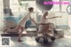 Two women pushing a shopping cart in a laundry room.