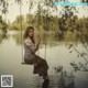 A woman sitting on a swing in the water.