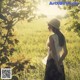 A woman standing in a field of tall grass.