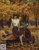 A woman sitting on a motor scooter in the woods.