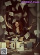 A woman sitting on top of a pile of books.