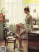 A woman sitting on a chair in front of a desk.